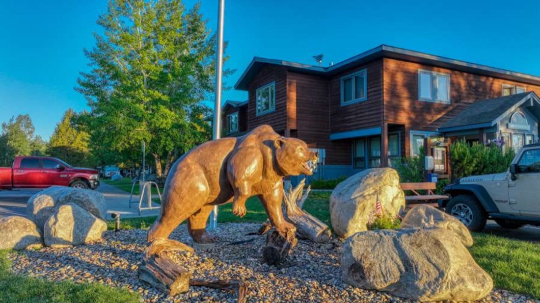 The bear statue and cabins at Yellowstone Grizzly RV Park